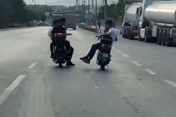 Elektrikli motosiklete yan oturan sürücünün tehlikeli yolculuğu